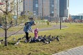 Mother and child feed pigeons in a residential area of Ã¢â¬â¹Ã¢â¬â¹Krasnoyarsk on a sunny autumn day
